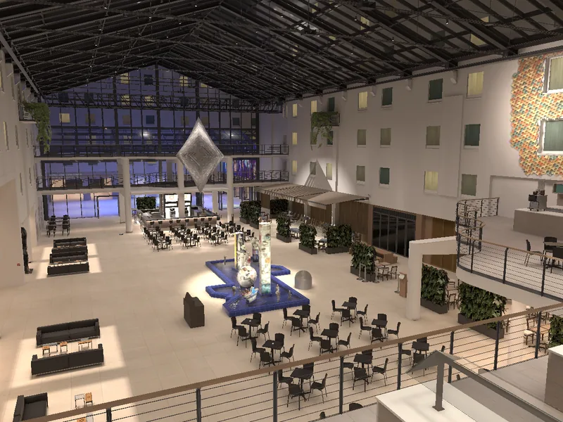 A glass-roofed hotel atrium seen from a balcony, with a blue fountain and cafe tables on the floor below.